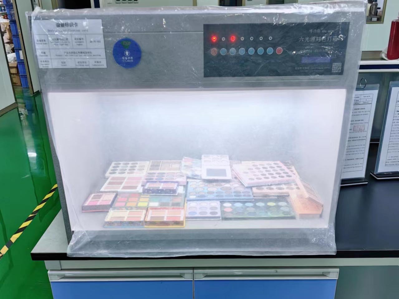 The color testing equipment in the cosmetics factory is powered on and running.
